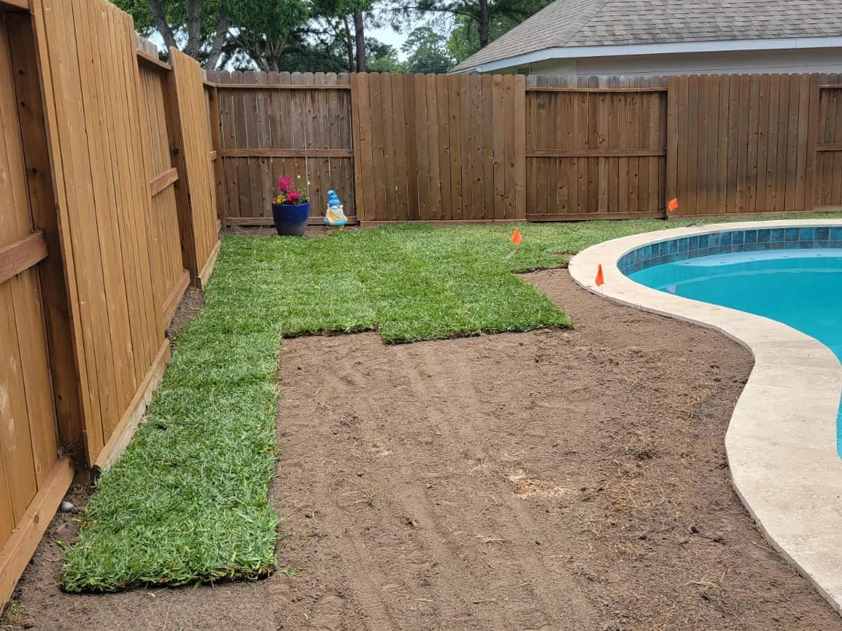 Prepared soil and new fence beside a backyard pool