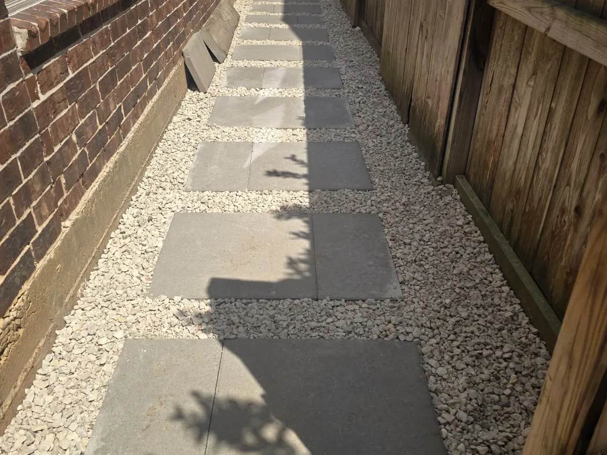 Finished side-yard path of concrete pads in gravel